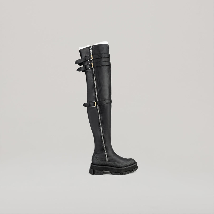 both X DION LEE black platform thigh-high shearling boots with side zipper and buckle straps
