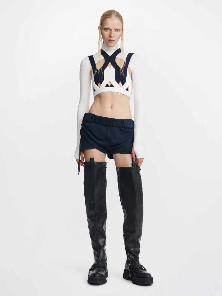 Model wearing black DION LEE-GAO platform thigh high boots with modern cut-out top and shorts.