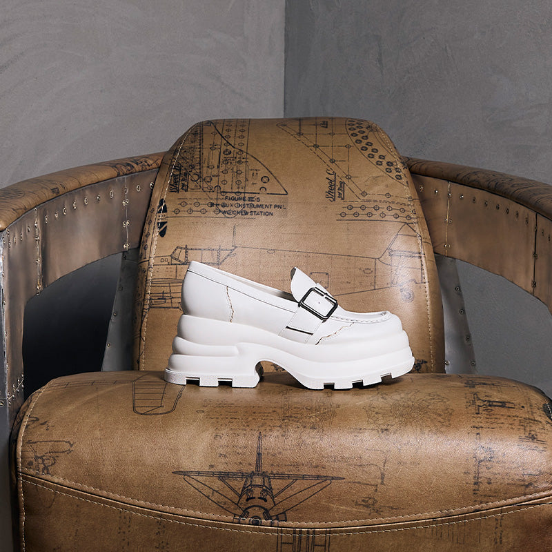 White platform buckled loafer from both x CHARLES & KEITH collection displayed on vintage leather chair