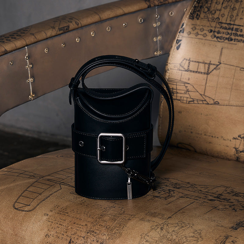 both x CHARLES & KEITH black bucket bag with structured silhouette on vintage chair